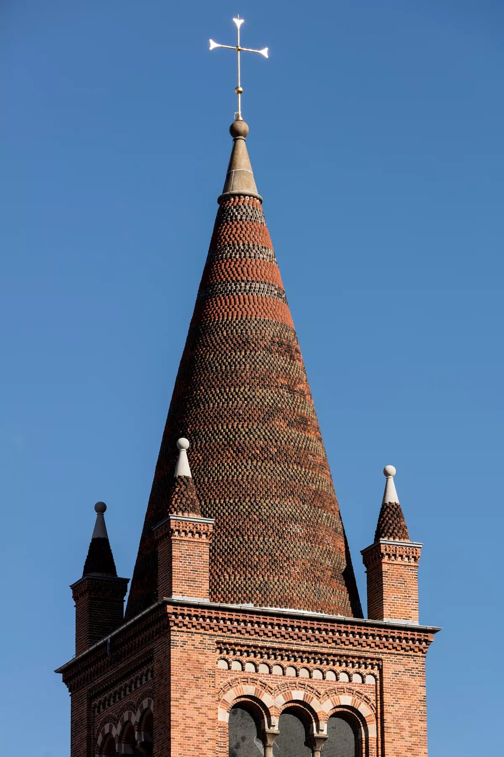 Spiret på Sankt Pauls Kirke i tegl, set tæt på mod blå himmel