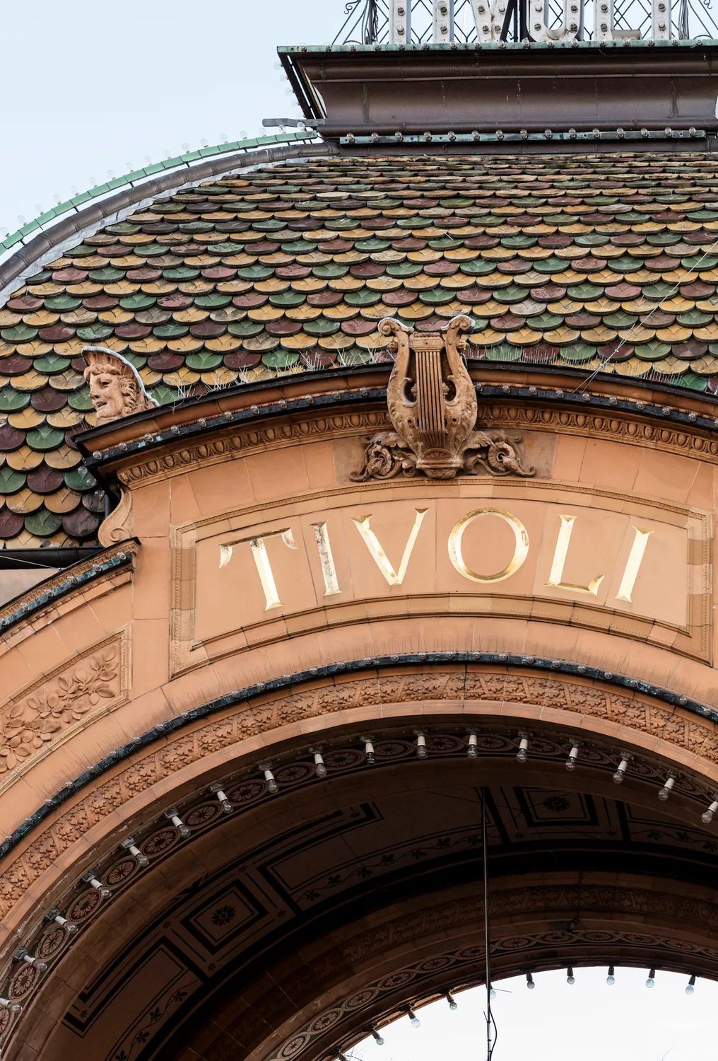 Buen over Tivolis hovedindgang med skriften TIVOLI, lyren og det glaserede skældækkede tag