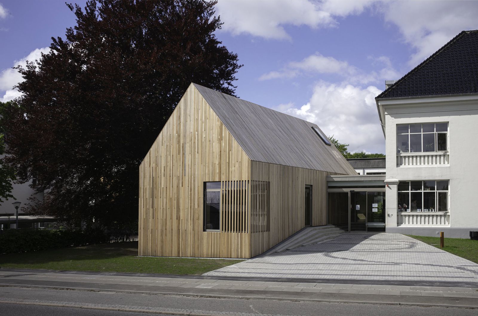Lys træfacade i lodrette lister på moderne dansk hus